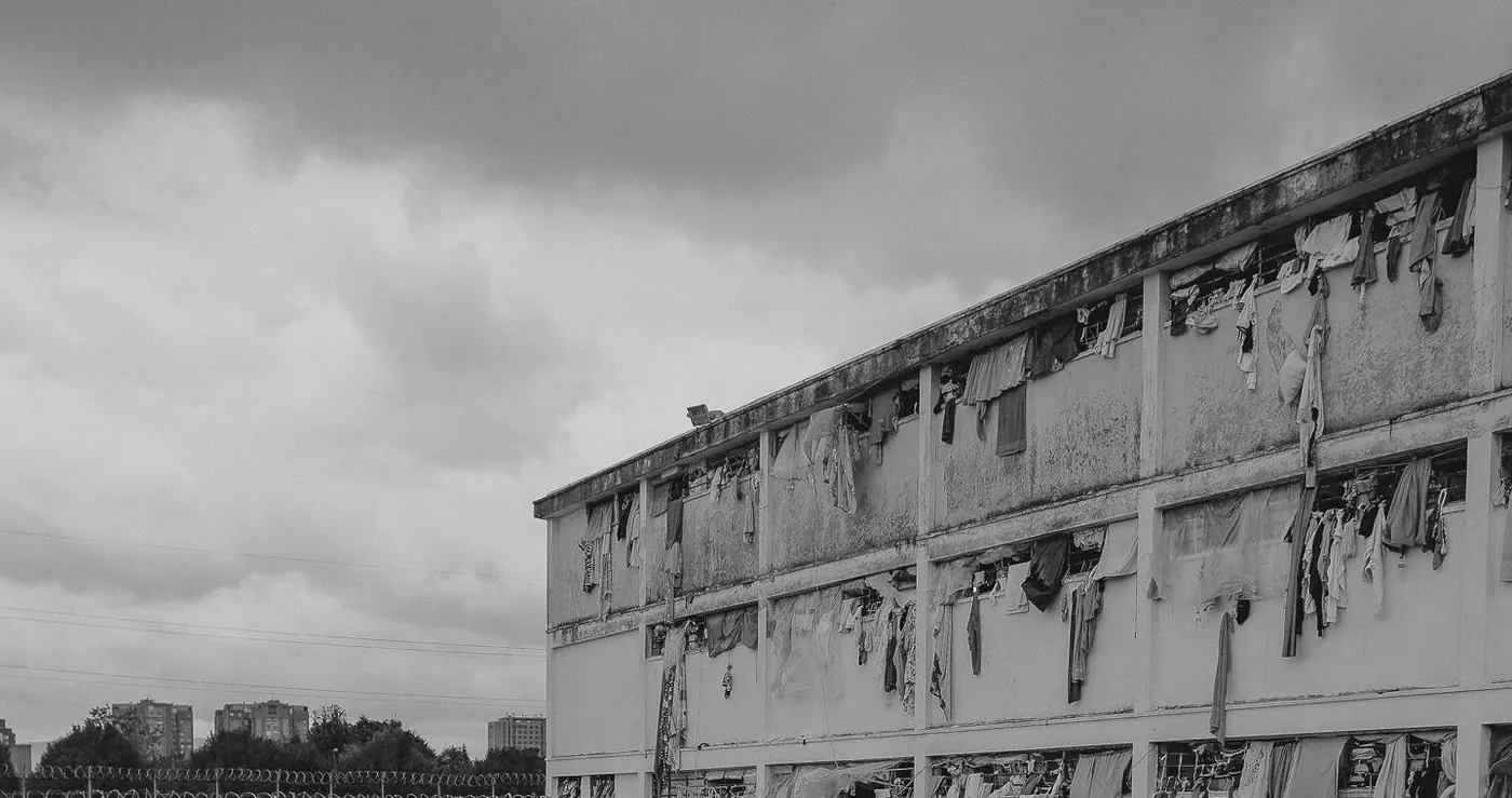 Muro y pabellón de la cárcel El Buen Pastor bajo un cielo nublado, en blanco y negro.